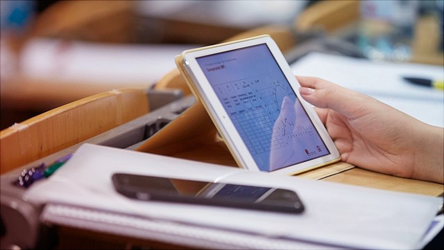 Szene im Audimax: Focus auf Smartphone und Tablet