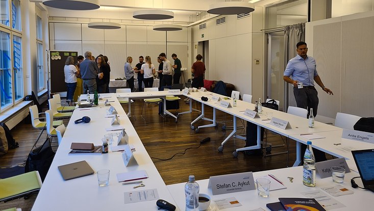 Workshop-Raum mit Teilnehmenden stehend am Buffet