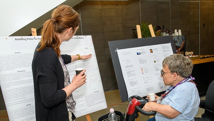 Dr. Wiebke Szymczak und ein weiterer Teilnehmer vor dem Poster zu Dr. Szymczaks Paper