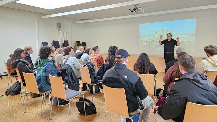 Man sieht einen Seminarraum mit Studis und der Lehrende hält eine Präsentation
