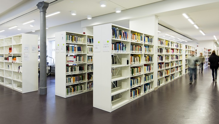 Regale mit Büchern, vorbeigehende Menschen/Shelves with books, people walking/