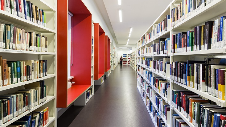 Blick entlang Regalen mit Büchern und Fensterarbeitsplätzen/View along shelves with books and window workspaces